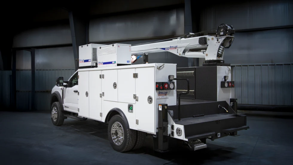 White service truck parked in a darkened industrial room. 