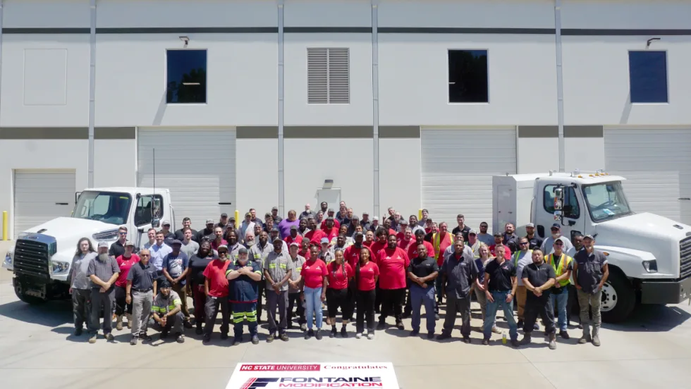 Group photos of people standing in front of two commercial trucks parked in front of a building.