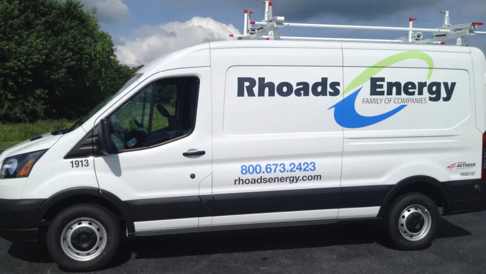 Photo of the side of a Ford Transit service van with company logo for Rhoads Energy.