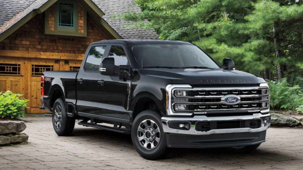 Black Ford Super Duty pickup truck parked in driveway of a home.