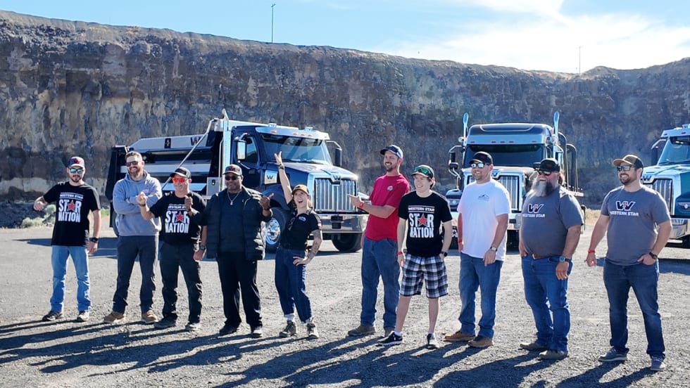 Group of vocational truck drivers and ATS gamers standing in front of Western Star trucks at the 2025 Star Nation Experience in Madras, Oregon.