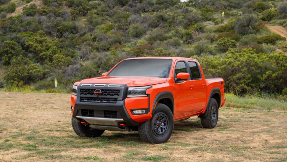 2026 Nissan Frontier PRO-4X in red parked outdoors on grass.
