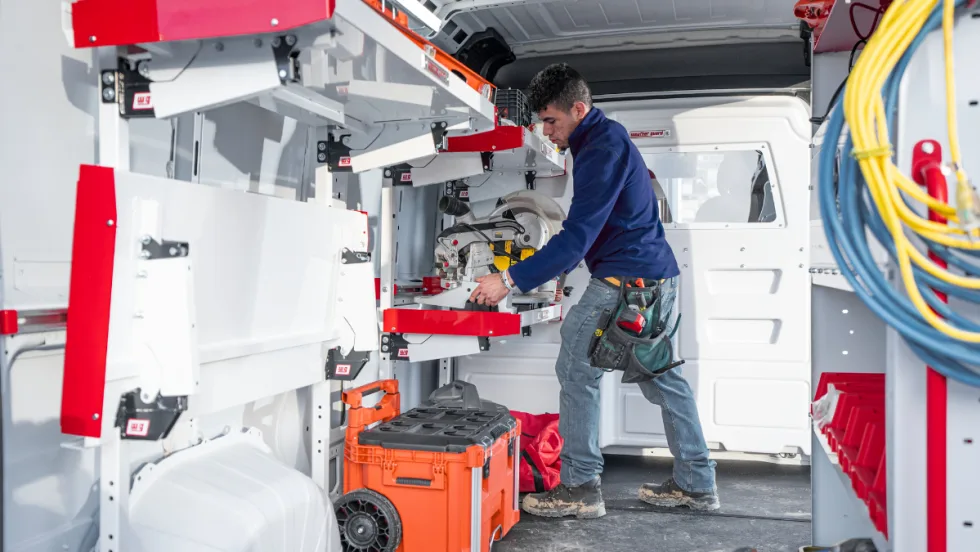 Worker inside a van with upfit shelving.