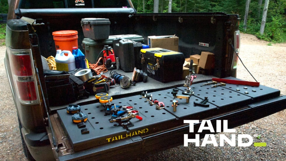 Pickup tailgate lowered and being used to secure tools.