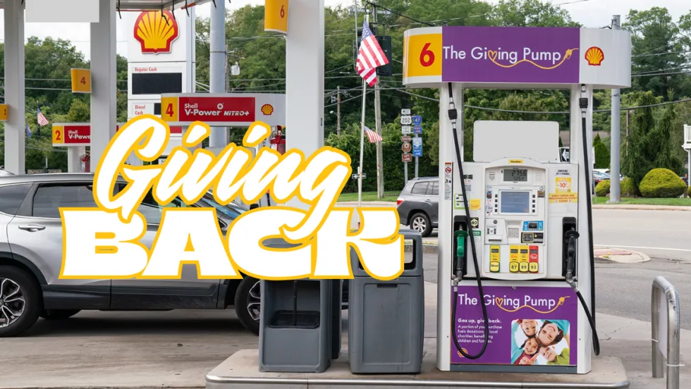 A Shell station featuring a purple Giving Pump where a portion of fuel sales is donated to local charities supporting children and families.