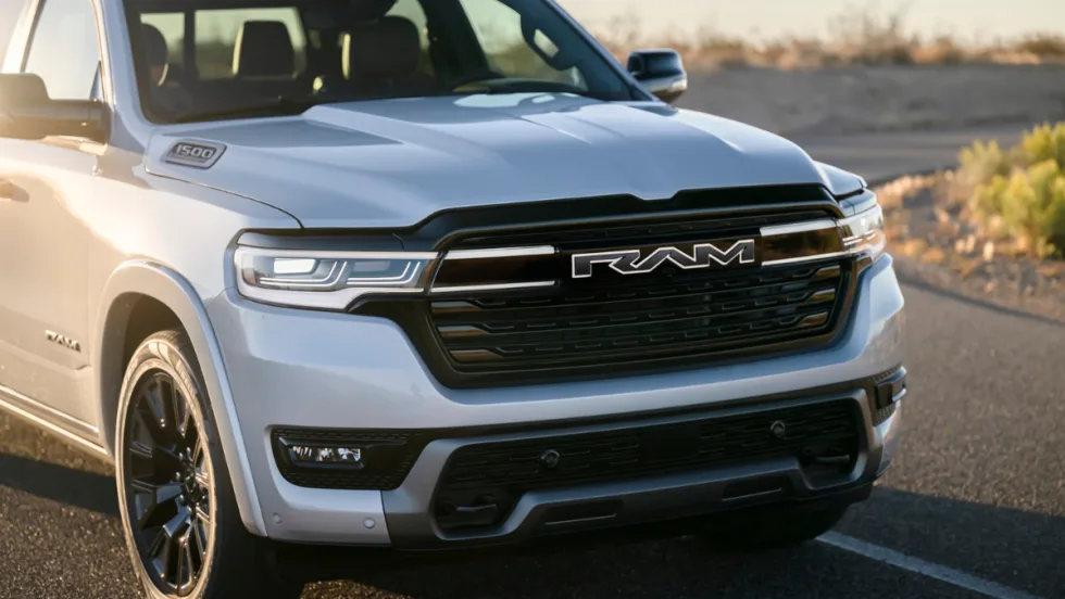 Front view of the Ram 1500 REV electric pickup in silver, showing bold RAM grille and headlights. The range-extended truck replaces Ram’s BEV plans, offering strong towing, payload, and range.