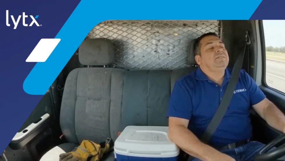 Truck driver asleep at the wheel, with logo for Lytx in the upper left corner.