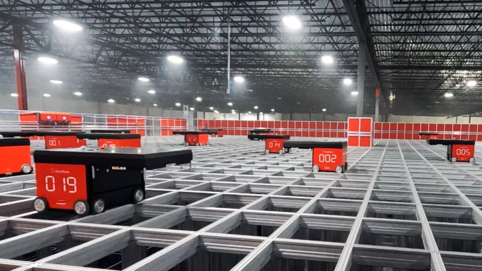 Robotic order pickers navigate on top of a grid.