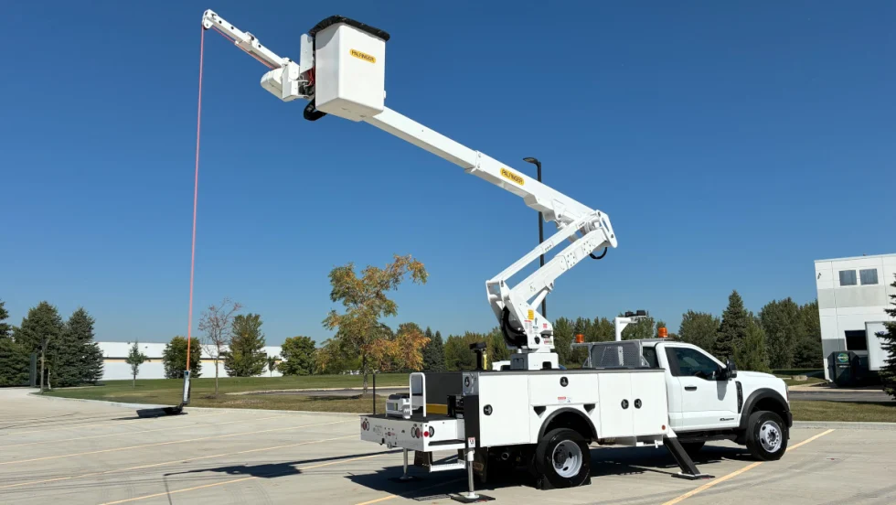 A utility bucket truck extended against a blue sky.