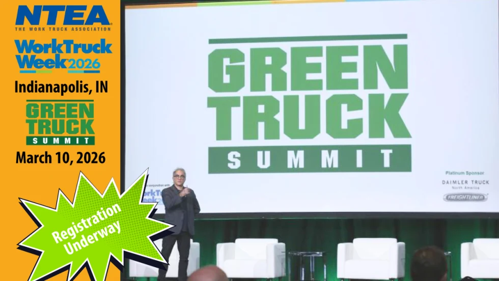 Man speaking on stage with huge screen that has Green Truck Summit logo. Left side of image has orange background and logos for NTEA, Work Truck Week, and Green Truck Summit.