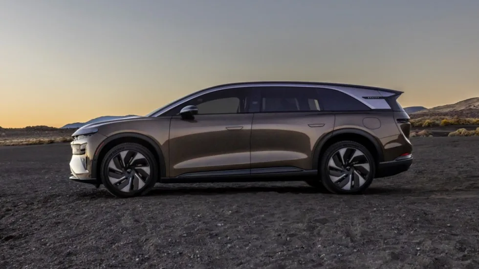 Side profile of the Lucid Gravity Touring electric SUV parked at sunset in a desert landscape.