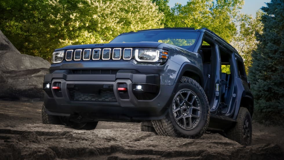 Jeep Recon on rocky terrain with one door removed and LED lights on.