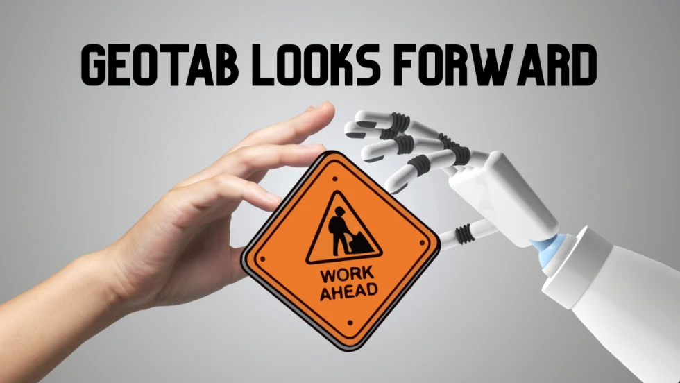 Human and robot hands hold a road sign reading Work Ahead, representing Geotab’s 2026 fleet predictions focused on AI, autonomy, and data quality.
