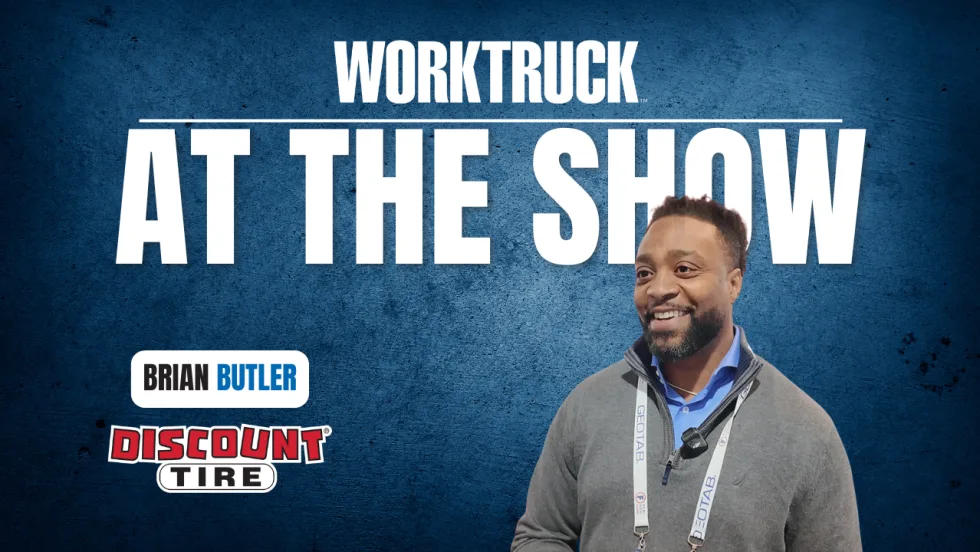 Chase Loyd of FASTER Asset Solutions smiling at the Work Truck At The Show booth, discussing fleet management software, public fleet challenges, and tools that reduce downtime.