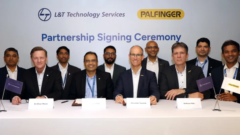 Group of men in business attire seated at a table to sign agreements.