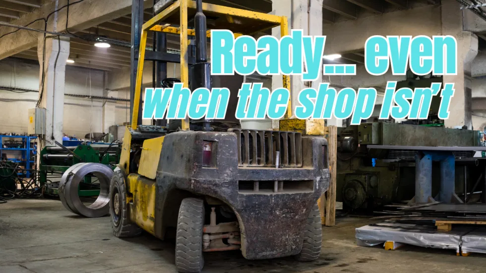 Old industrial forklift inside a workshop, showing heavy wear and tear, representing equipment maintained and used in challenging conditions.