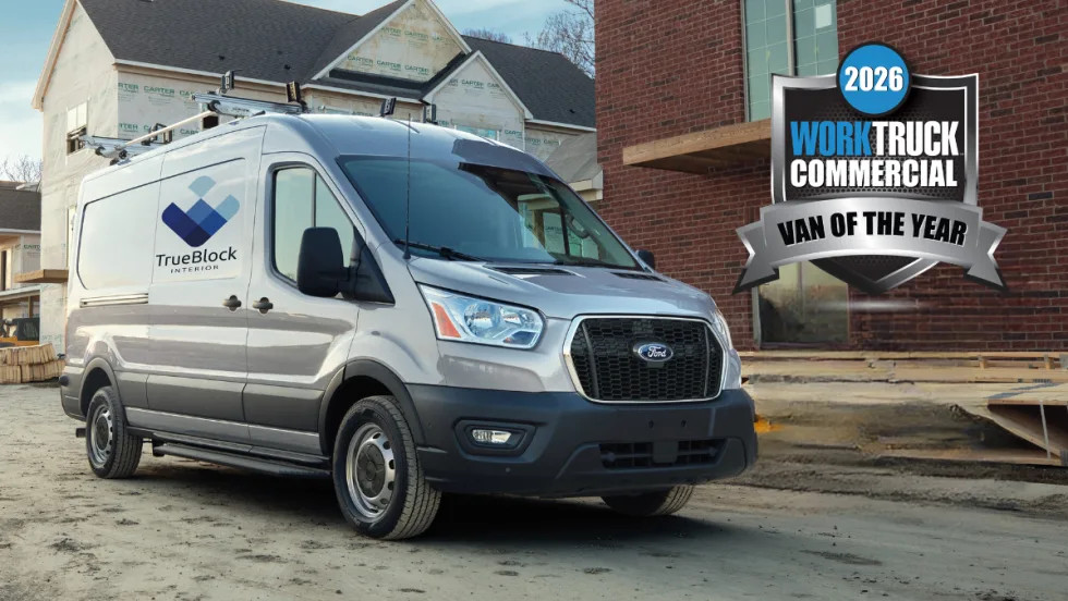 Ford Transit work van with TrueBlock Interior branding parked at a construction site, alongside a 2026 Work Truck Commercial Van of the Year award badge.