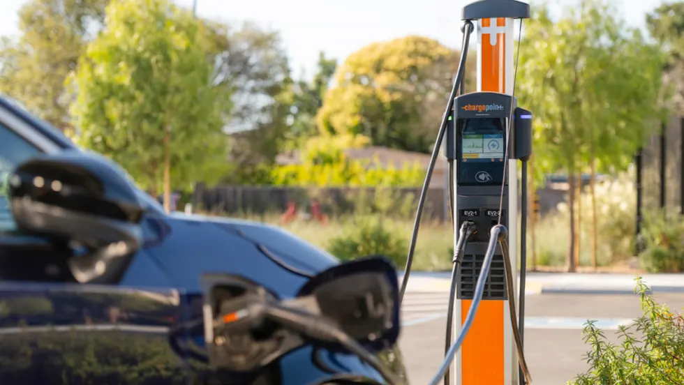 Electric vehicle connected to a ChargePoint charging station outdoors, illustrating campus EV charging infrastructure.