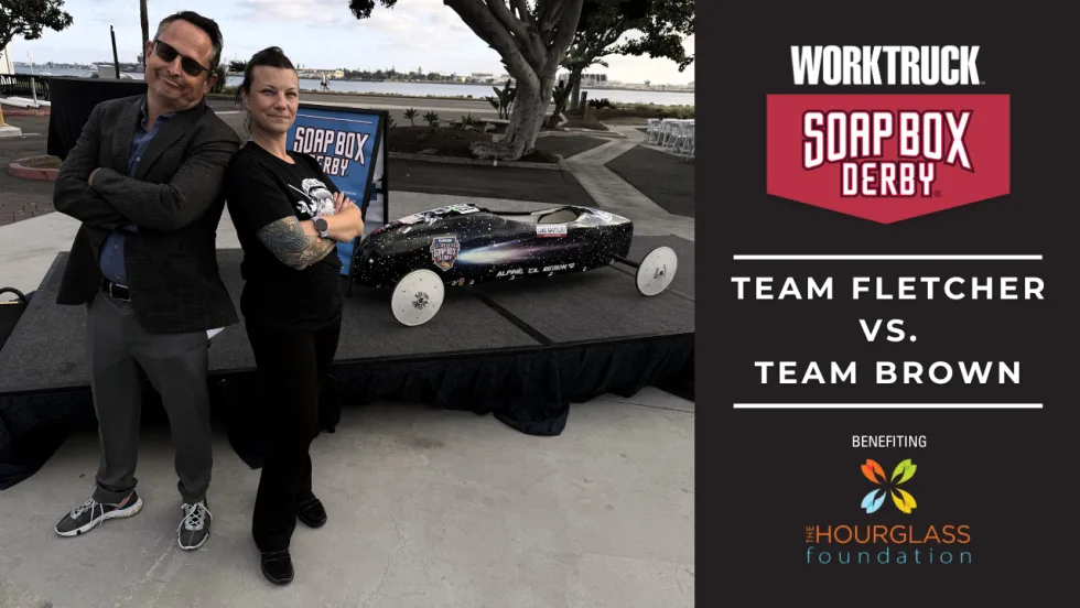 Lauren Fletcher and Chris Brown stand beside a soap box derby car ahead of the 2026 Corporate Soap Box Derby Challenge, where Team Fletcher will race to support skilled trades scholarships.