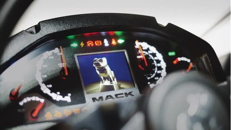 Closeup photo of a truck instrument cluster with a digital dash including an image of the Mack bulldog.