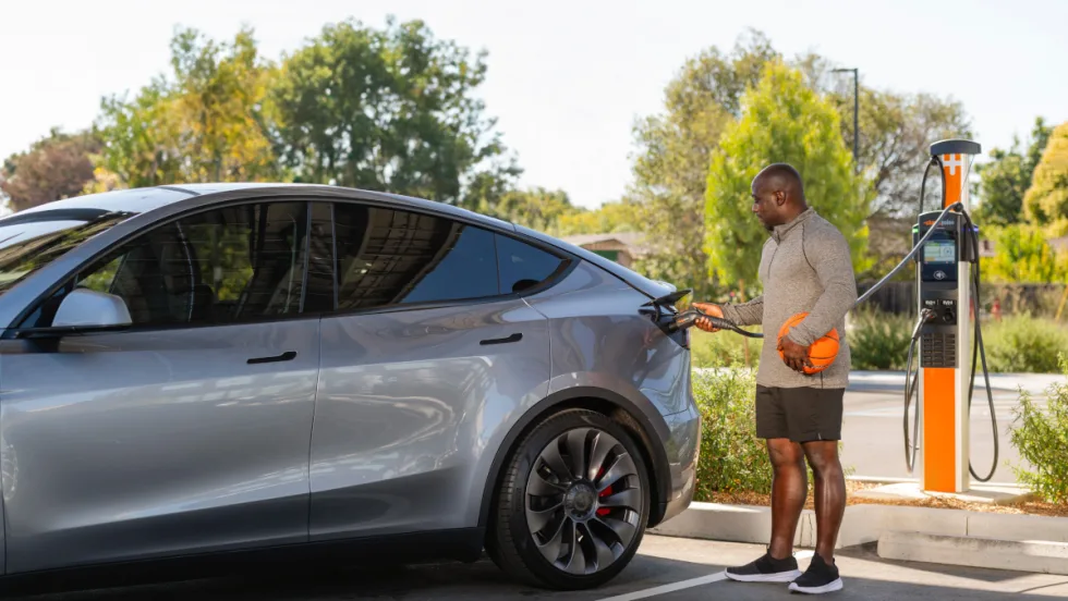 Photo of a man charging an EV car.