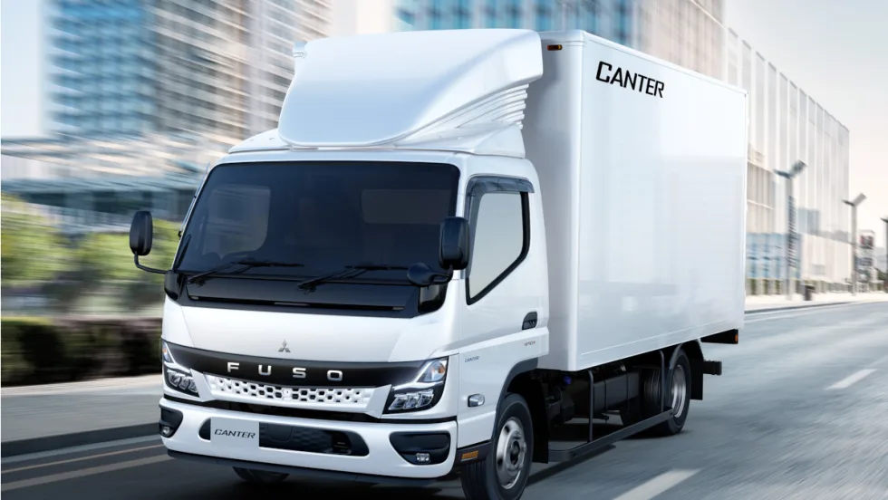 White box truck driving through city streets.