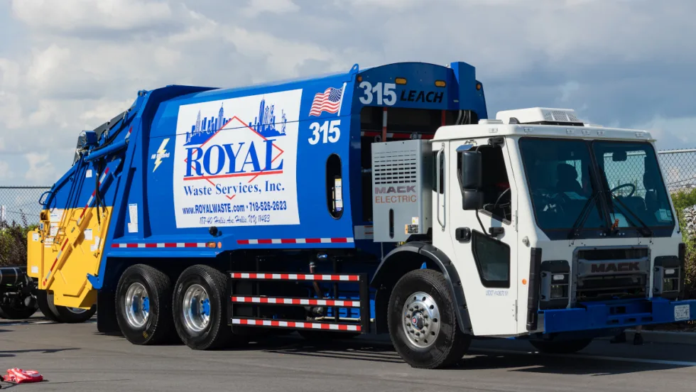 Front quarter view of a blue electric refuse truck.