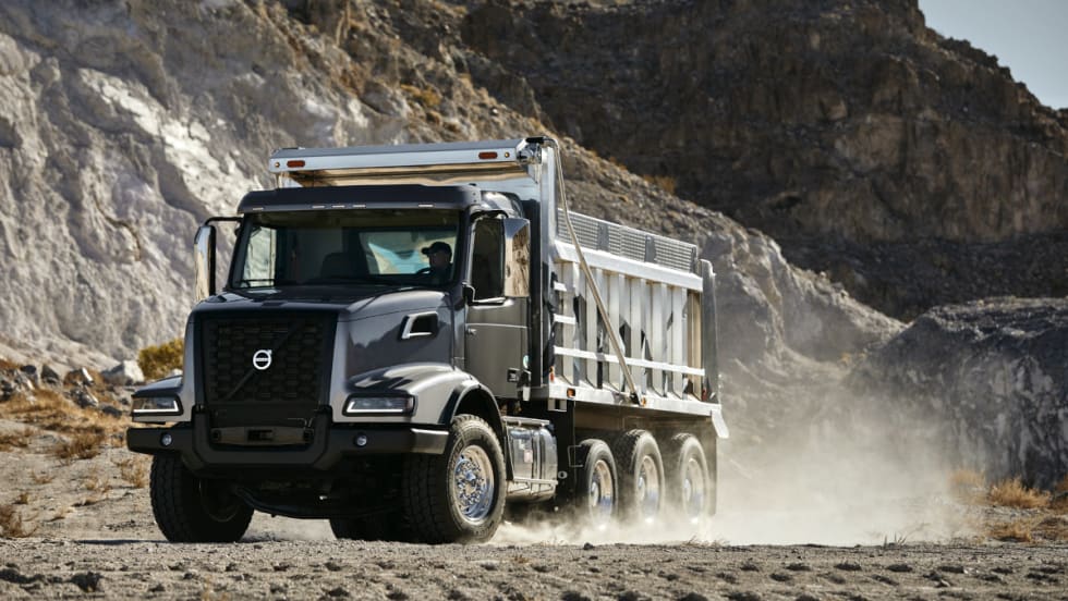 Dump truck driving across dirt.