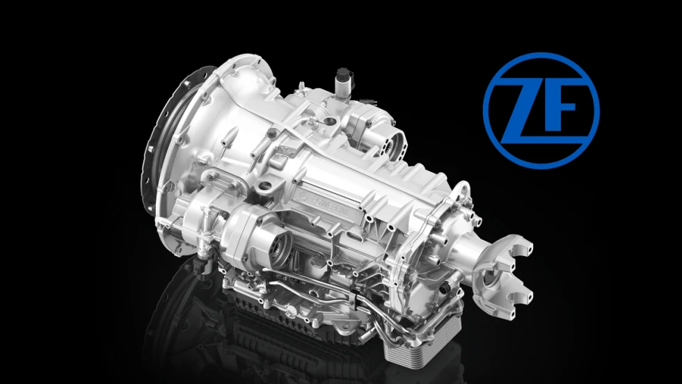 Silver truck transmission against a black background and a blue ZF logo.