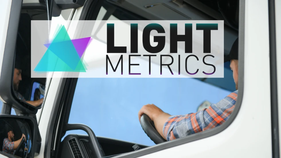 Side view of a man in a truck cab with overlay of logo for LightMetrics.