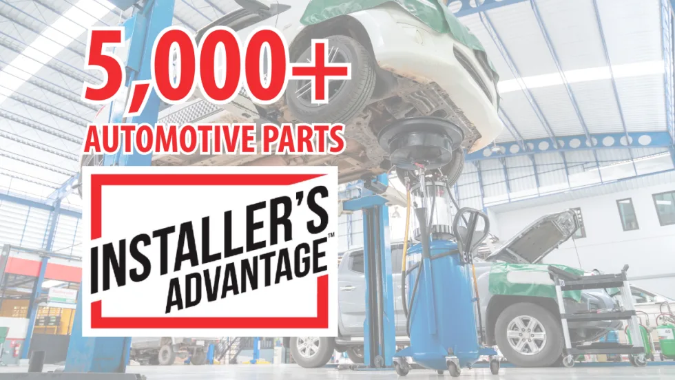 Promotional graphic for Installer’s Advantage featuring “5,000+ Automotive Parts” text over an auto repair shop scene with vehicles on lifts, service equipment, and technicians’ work bays in the background.