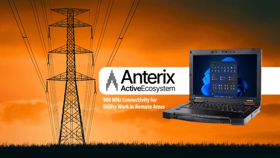 Image promoting the Anterix Active Ecosystem with 900 MHz connectivity for utility work in remote areas. The image features power transmission lines at sunset alongside a rugged Panasonic Toughbook laptop displaying a Windows interface.