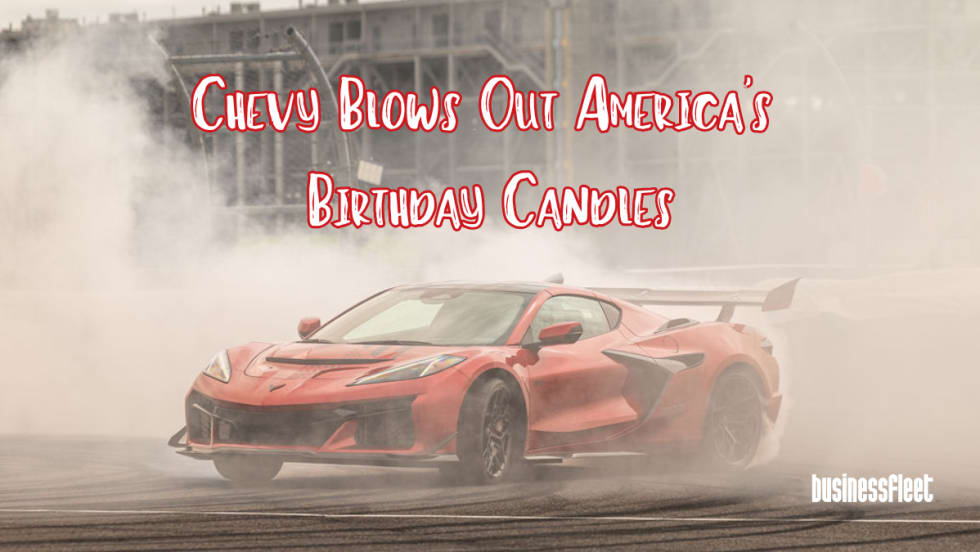 A red Chevrolet Corvette performs a burnout surrounded by smoke at Indianapolis Motor Speedway with text overlay reading “Chevy Blows Out America’s Birthday Candles” and Business Fleet branding in the corner.