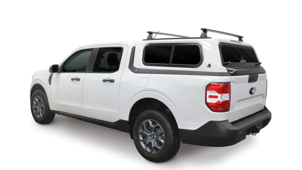 White Ford Maverick pickup equipped with a LEER truck cap and roof rack, shown from the rear three-quarter view, highlighting an integrated cargo solution for fleet, commercial, and utility applications.