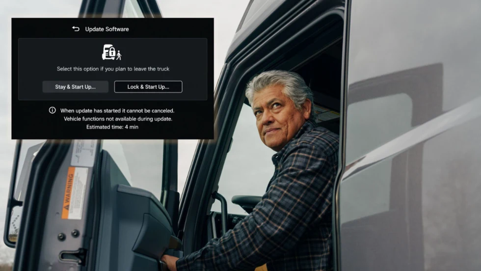 Truck driver seated in a commercial truck cab beside an over-the-air software update screen showing “Lock & Start Update” options, illustrating remote vehicle software updates that can be completed while the driver is away from the truck.