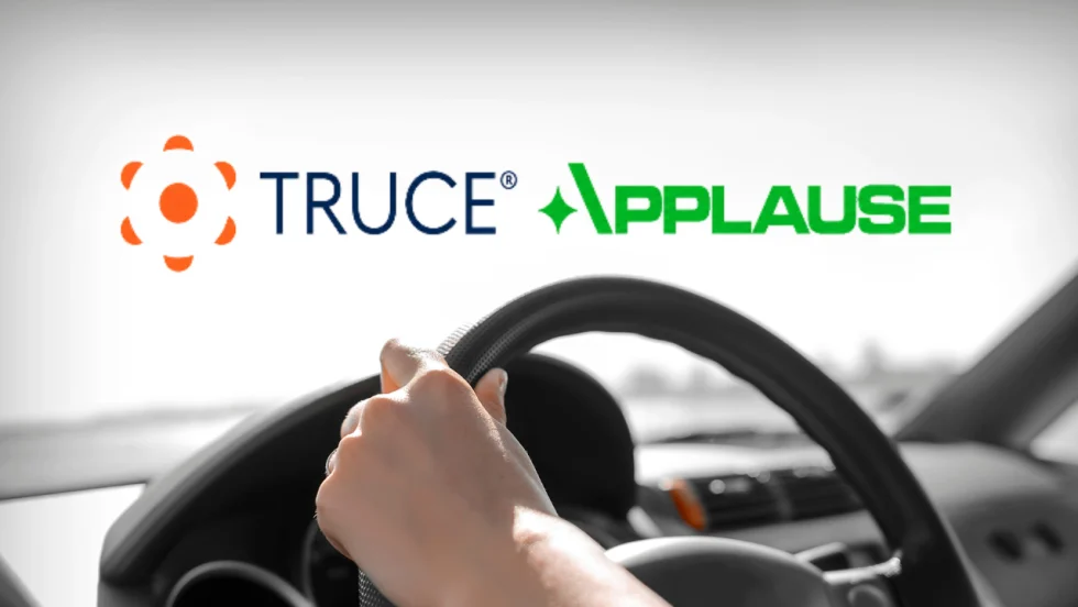 Promotional image announcing a partnership between TRUCE and Applause, featuring a driver’s hands on a steering wheel to represent connected fleet technology, driver safety, and mobile device management.