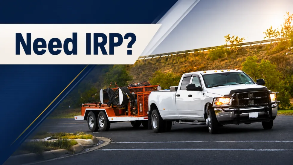 White work truck towing a tandem-axle equipment trailer on a roadway with “Need IRP?” displayed above the vehicle.