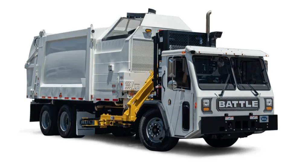 White Battle Motors refuse truck with a Heil side-loading waste collection body and yellow hydraulic lifting arm, shown against a plain white background.