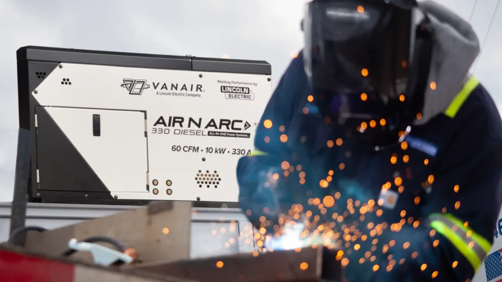 Welder creates bright sparks while working beside a Vanair Air N Arc 330 Diesel all-in-one power system featuring Lincoln Electric welding performance.