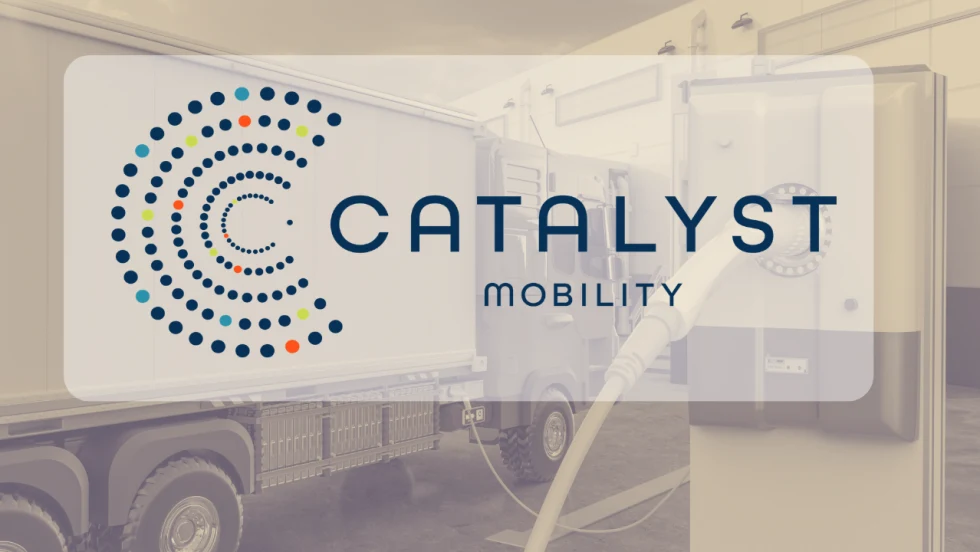 Catalyst Mobility logo displayed over an image of an electric commercial truck connected to a charging station inside a facility.