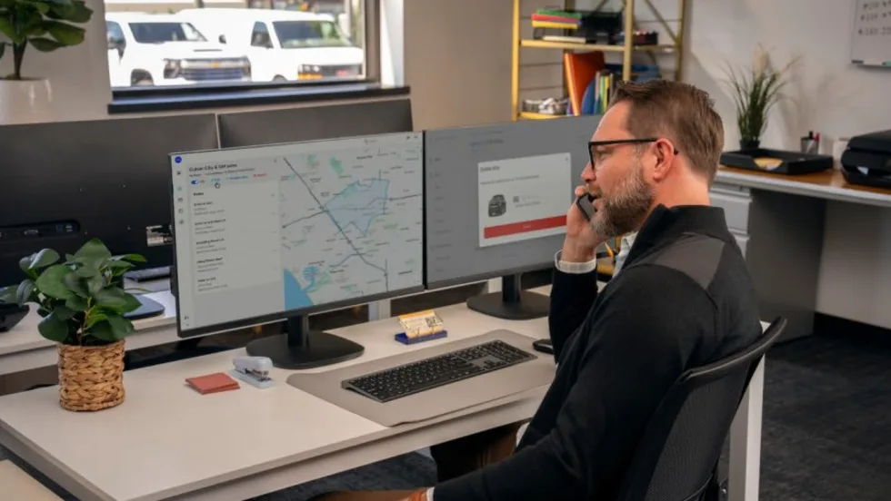 A man sitting at his desk with his phone to his ear