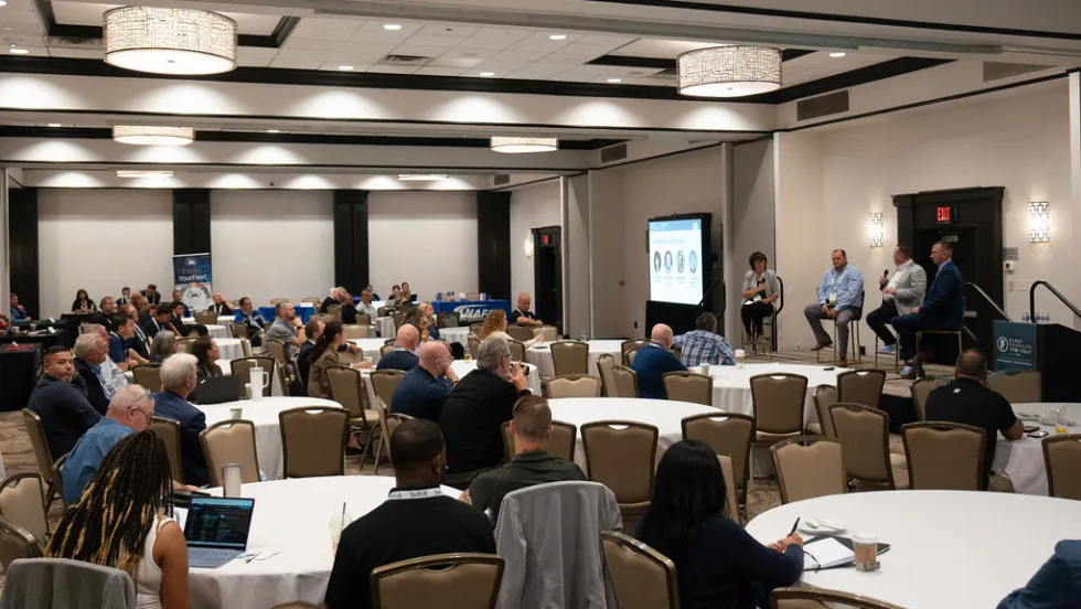 Wide shot of hotel conference room during a presentation. 