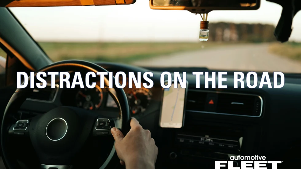 A person with hands on the steering wheel driving