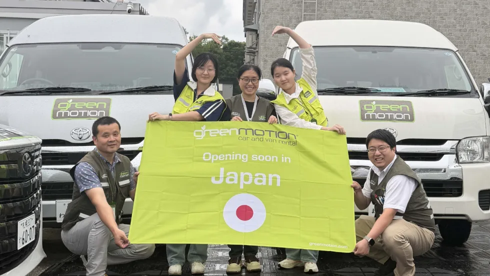Green Motion team with banner bearing Japanese flag.
