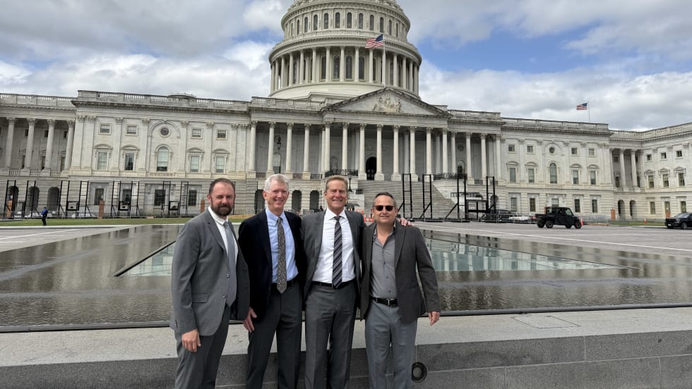 Four ACRA members stand in front of U.S. Capitol