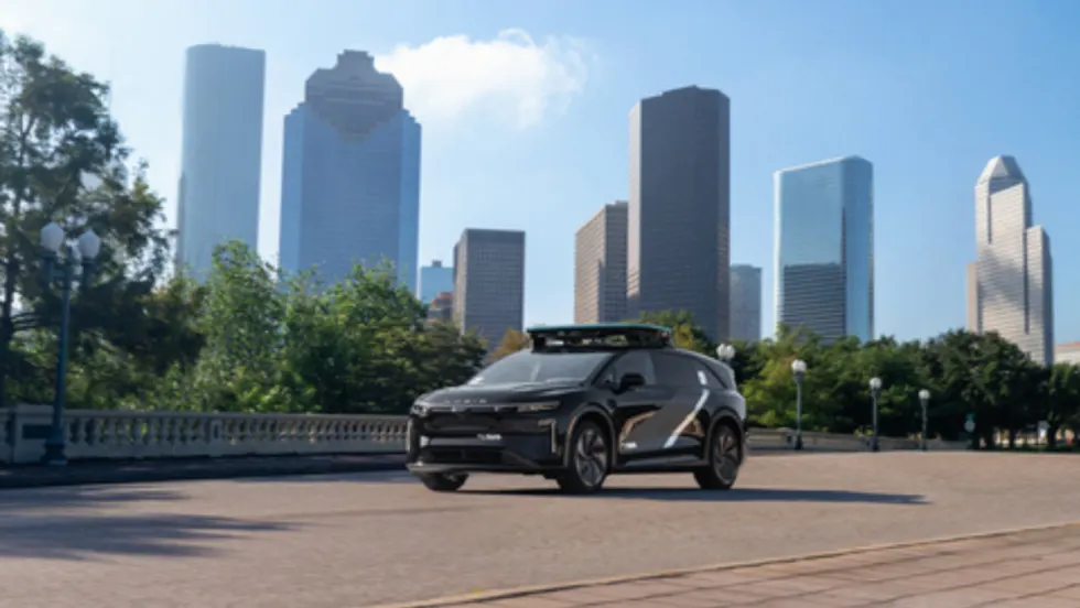 A Lucid Gravity robotaxi parked in front of the Houston skyline.