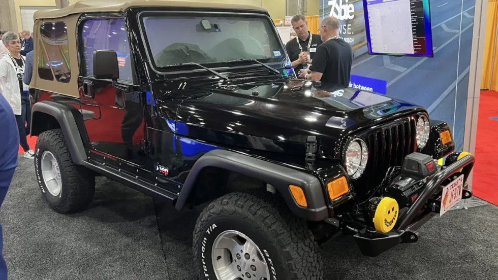 A black Jeep is displayed at the Zubie-Bosch-TSD exhibit during the International Car Rental Show.