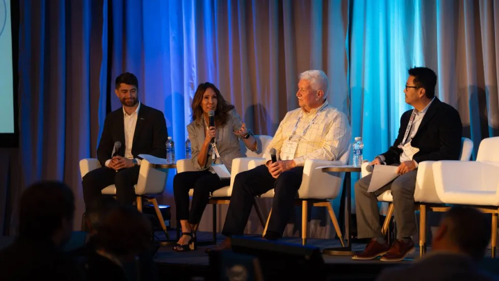 A panel of remarketing managers and experts on stage before a conference audience.