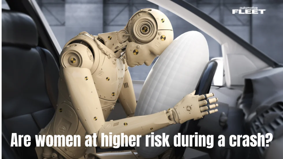 A female crash dummy has her head down on a steering wheel