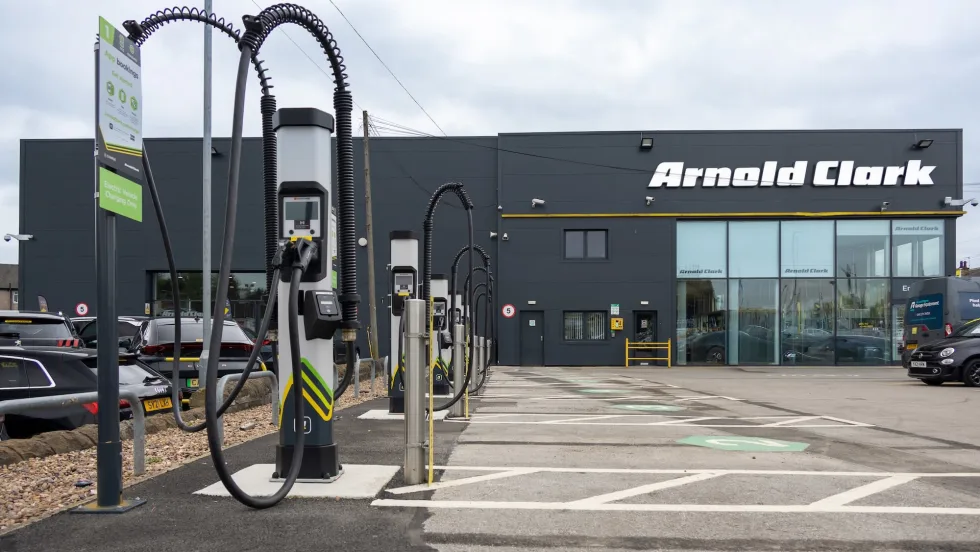 An Arnold Clark black building with an electric charger out front